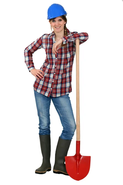 Портрет женщины-каменщика, опирающейся на лопату — стоковое фото