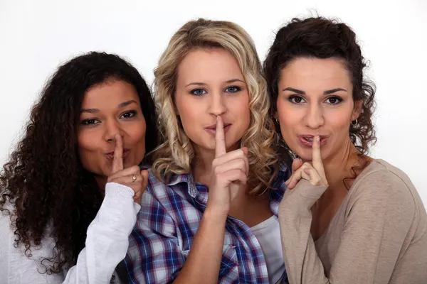 Tres mujeres haciendo un gesto de silencio — Foto de Stock