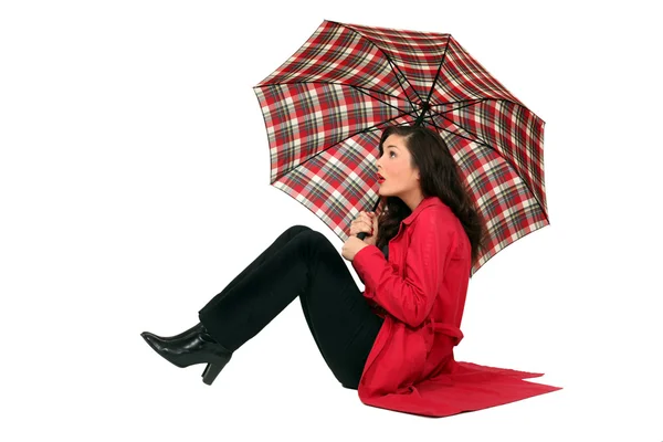 Scottish woman sitting with umbrellas — Stock Photo, Image