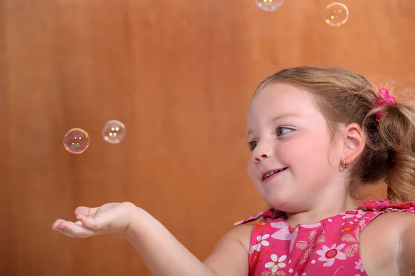 Kleines Mädchen fängt Blasen — Stockfoto
