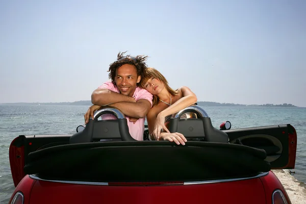 Casal em umas férias de verão abraçando em seu carro — Fotografia de Stock