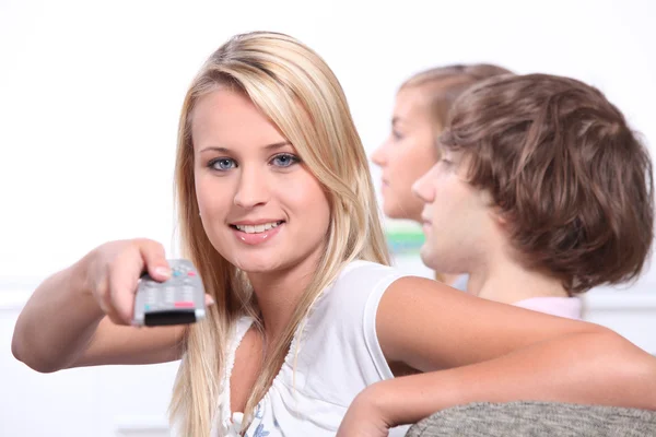 Adolescenti che guardano la televisione e usano il telecomando — Foto Stock