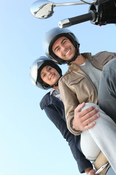 Casal em uma scooter na luz do sol — Fotografia de Stock