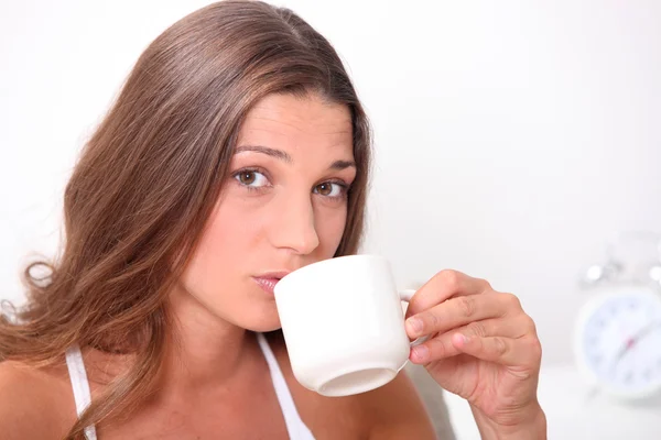 A cute brunette drinking coffee. — Stock Photo, Image