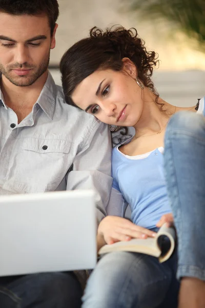 Paar mit Laptop und Buch — Stockfoto