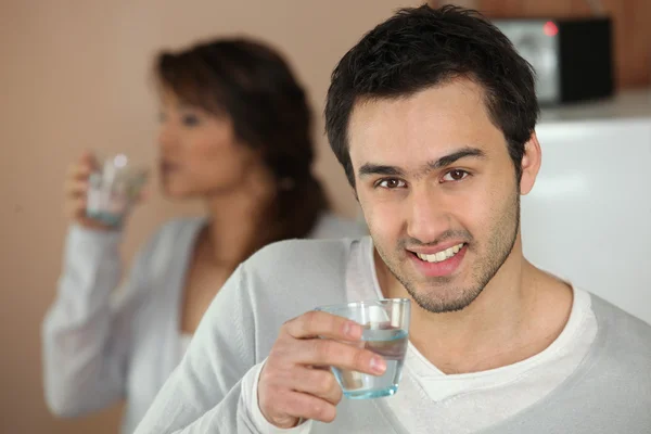 Пара випиває склянки води вдома — стокове фото