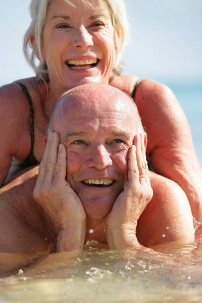 Starší pár, koupání v moři — Stock fotografie
