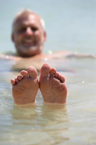 Mann stochert mit den Füßen aus dem Wasser — Stockfoto
