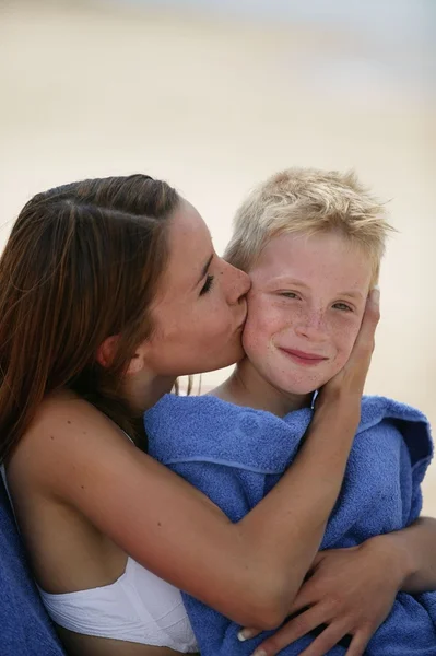 Γυναίκας φιλάει το γιο της σε μια παραλία — Φωτογραφία Αρχείου