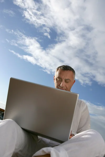 Człowiek z komputerem na nogi — Zdjęcie stockowe