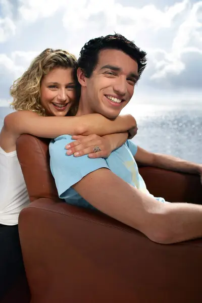 Mann und Frau umarmen sich auf Sessel — Stockfoto