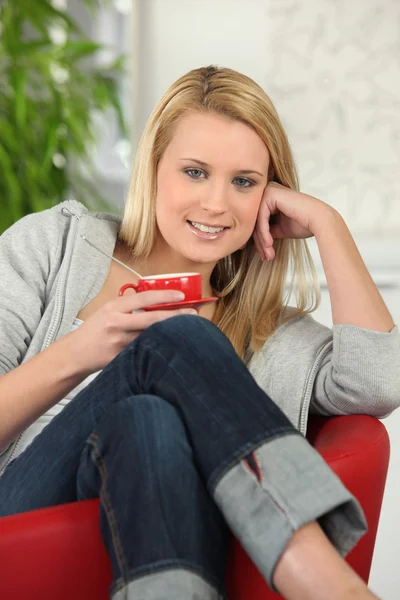 Mujer joven bebiendo café en el sofá —  Fotos de Stock