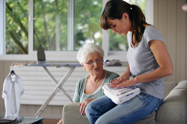Young woman helping senior lady with the housework — Stock Photo, Image