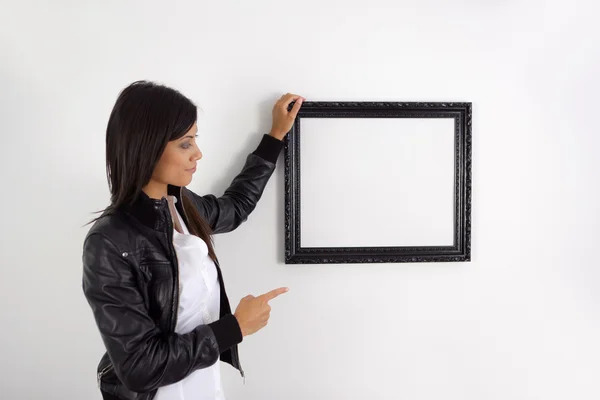 Femme pointant vers un cadre photo — Photo