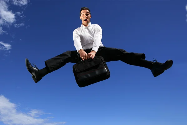 Экстатичный бизнесмен прыгает с портфелем — стоковое фото