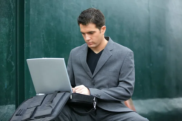 Biznesmen za pomocą swojego laptopa w ruchu — Zdjęcie stockowe