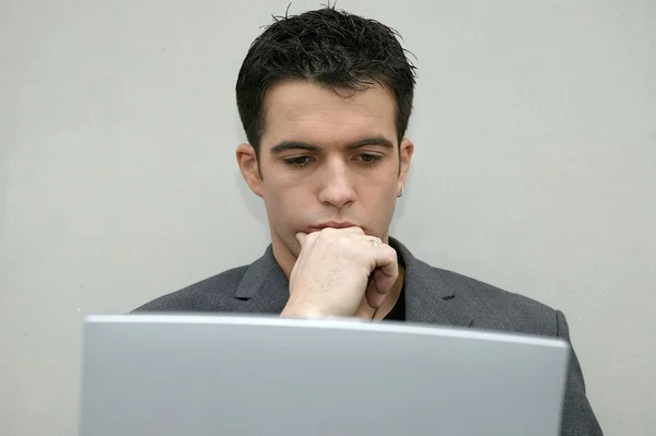Серьезный человек смотрит на свой ноутбук — стоковое фото