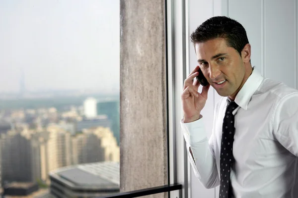 Empresário fazendo chamada por janela — Fotografia de Stock