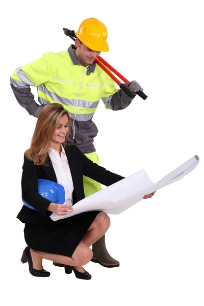 Architect kneeling by builder with plans — Stock Photo, Image