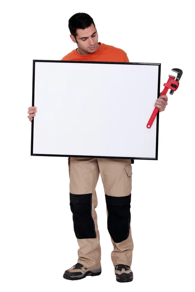 Hombre con panel blanco y llave inglesa — Foto de Stock
