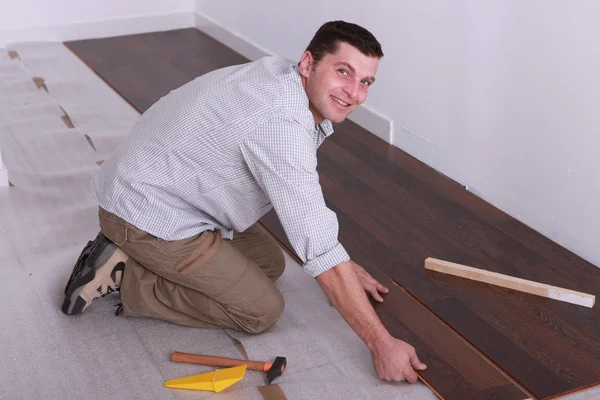 Homem entalhando laminado, piso juntos — Fotografia de Stock