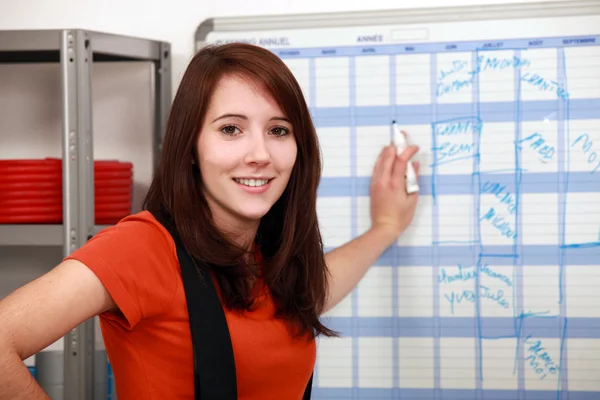 Factory worker filling the schedule — Stock Photo, Image