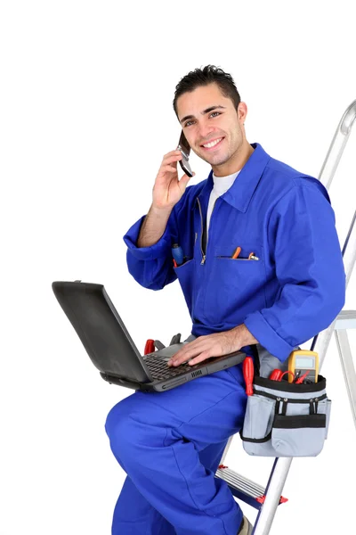 Elektricien met een telefoon en een laptop — Stockfoto