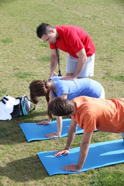 Personal trainer helping his client clipart