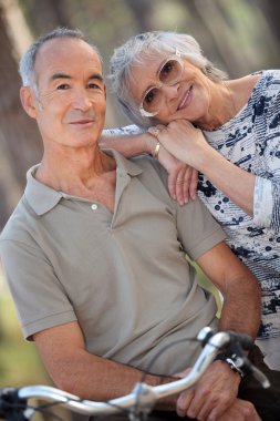 Senior couple riding bikes clipart