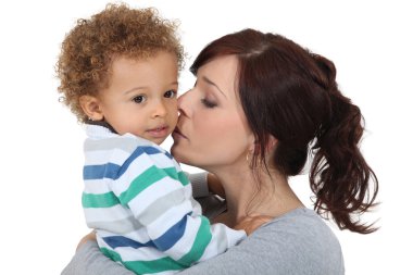 Mother kissing her little boy clipart