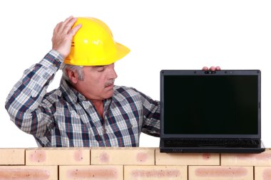 A mason with a laptop. clipart