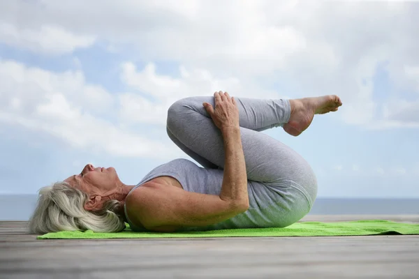 Donna che fa yoga sul molo — Foto Stock