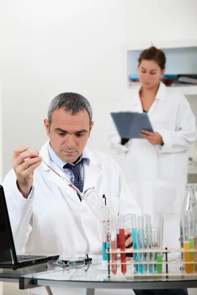 A scientist using test tubes — Stock Photo, Image