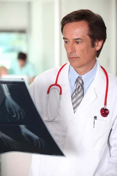 Чоловік-лікар аналізує зображення рентгенівського знімка — стокове фото