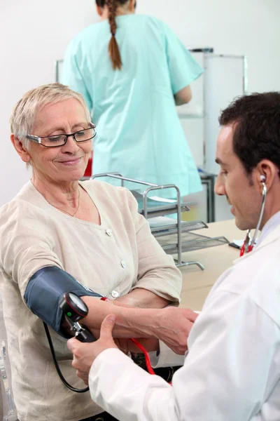 Doctor taking his patient's blood pressure — Stock Photo, Image