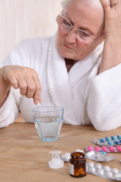 Cidadã idosa infeliz tomando sua medicação — Fotografia de Stock