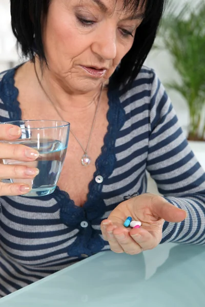Mature woman taking drugs — Stock Photo, Image