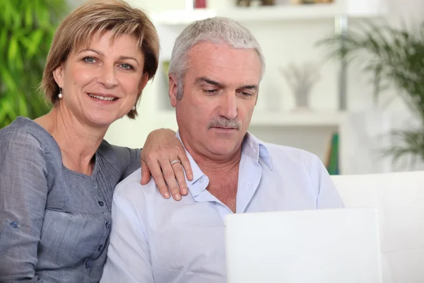 Casal casal usando um laptop em casa — Fotografia de Stock