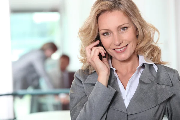 Bir ofiste bir cep telefonu kullanarak iş kadını — Stok fotoğraf