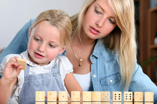 Chica joven jugando con dominó — Foto de Stock