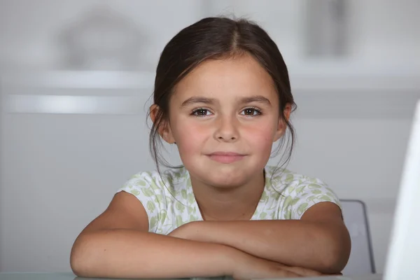 Kleines Mädchen saß am Tisch — Stockfoto