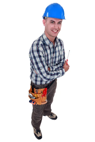 Comerciante sonriente sosteniendo un destornillador — Foto de Stock