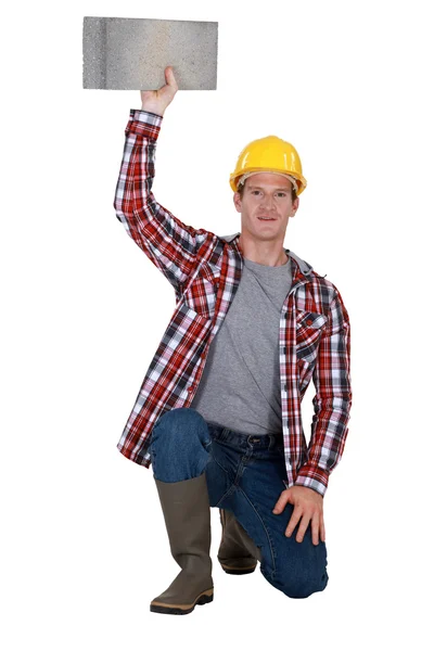 Portrait of bricklayer holding block of concrete — Stock Photo, Image