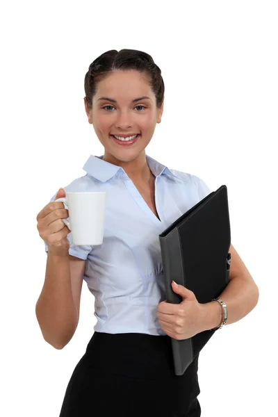 Брюнетка с чашкой кофе и папкой — стоковое фото
