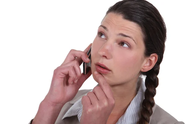 Сумнівна жінка розмовляє на мобільному телефоні — стокове фото