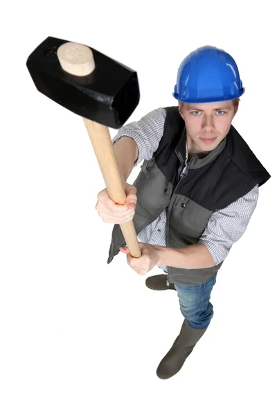 Construction worker holding a loft a sledgehammer — Stock Photo, Image