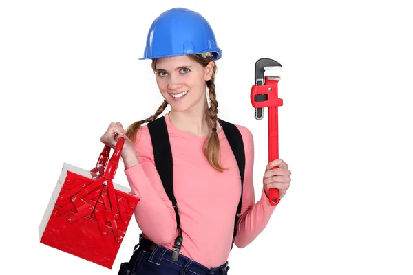Una trabajadora de la construcción con una llave inglesa y una caja de herramientas . — Foto de Stock
