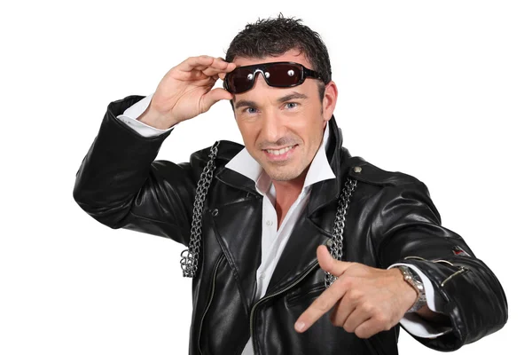 A smiling man wearing a leather jacket and sunglasses. — Stockfoto