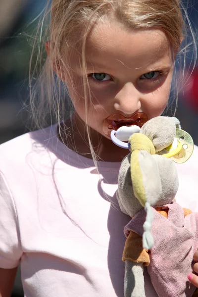 Menina com uma chupeta e um coelho de brinquedo sujo — Fotografia de Stock