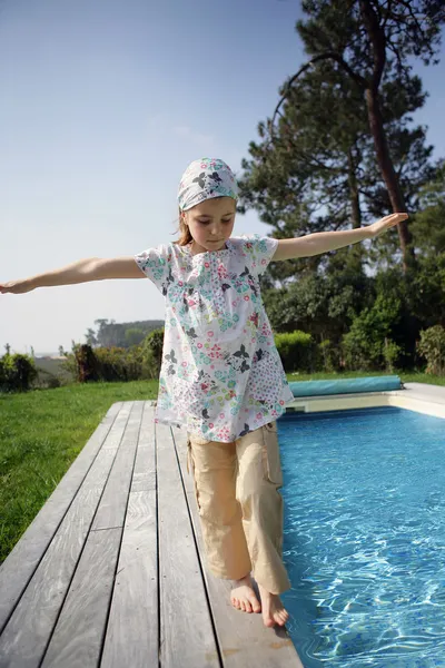 Klein meisje lopen naast een zwembad — Stockfoto